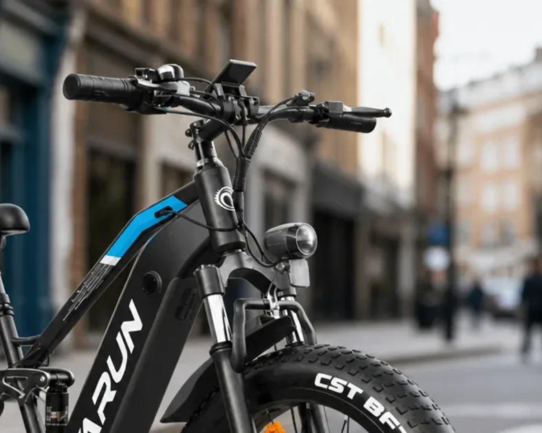 A row of Varun electric bikes including a fat tyre model, a folding model and a step through city bike, parked on a UK street.