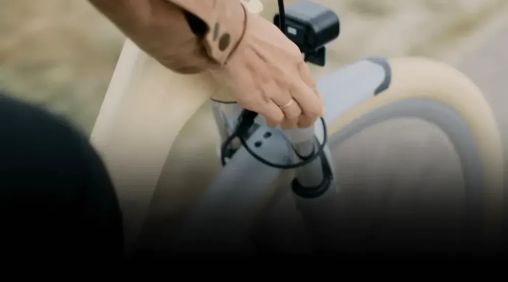 ADO Air 28's IPS color display showing speed and battery level, handlebar controls in view.