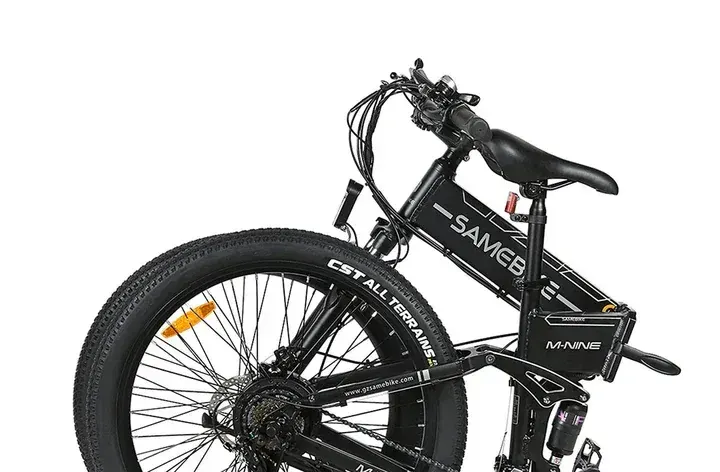 Rider on Samebike LO26-II-YD climbing a dirt trail with 26-inch tyres.