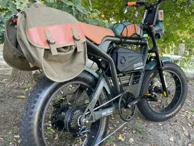 Samebike M20 dark green model riding on a city street, rider in casual attire.