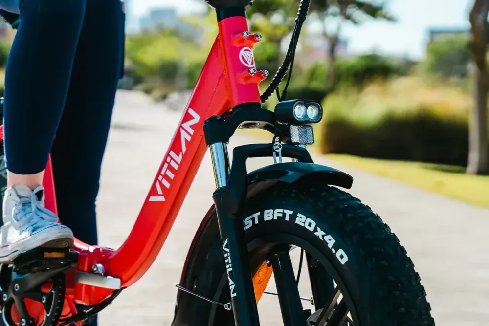 Vitilan U7 180mm hydraulic disc brake caliper and rotor on the front wheel, with suspension fork leg.